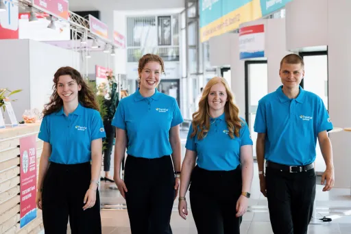 Dynamisches Interplan Kongress-Team kommt lachend entgegen.