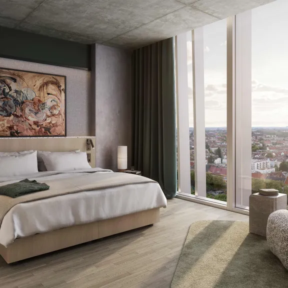 Modernes Schlafzimmer mit großem Bett, Sessel, Wandbild und Panoramafenster mit Stadtblick.