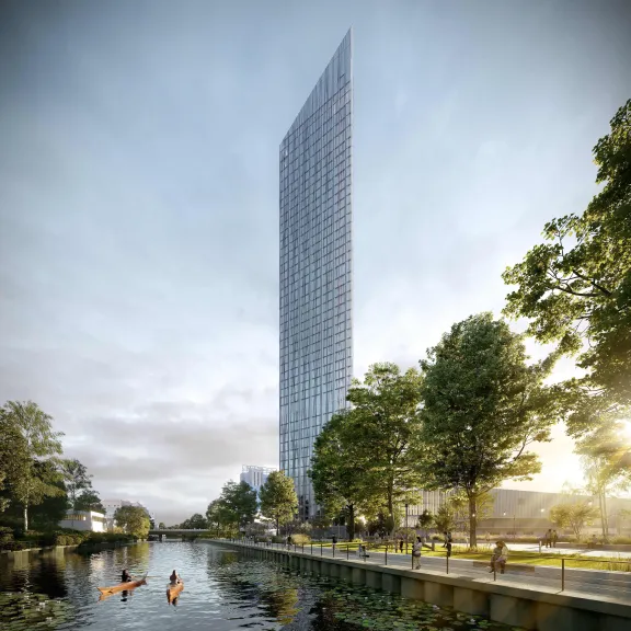 Hohes, modernes Hochhaus am Fluss, umgeben von Bäumen und Spaziergängern.
