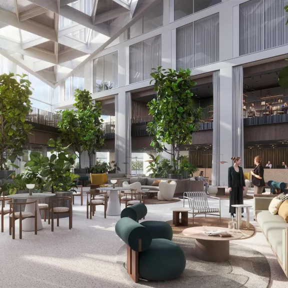 Großzügige, helle Lobby mit modernen Möbeln, vielen Pflanzen und Glasdecke