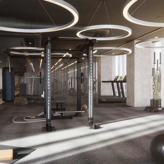 Modernes Fitnessstudio mit Trainingsgeräten, Hanteln und großen runden Deckenleuchten.