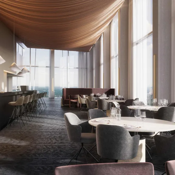 Modernes Restaurant mit großen Fenstern, runden Tischen und elegantem Design.
