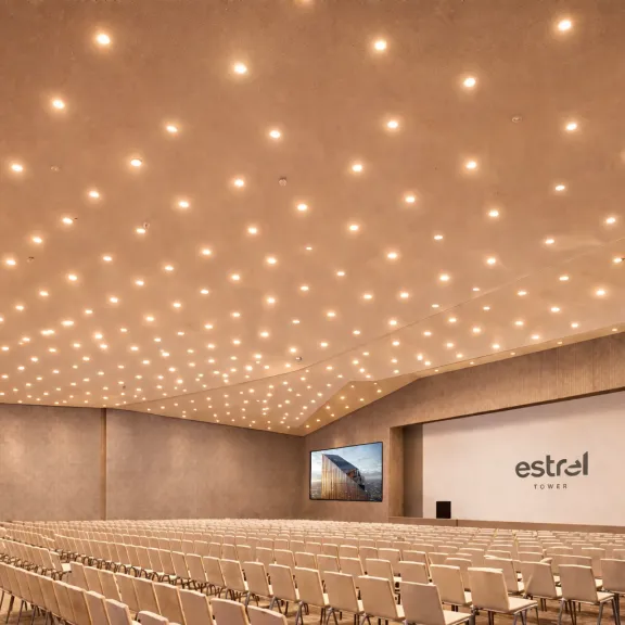 Großer, heller Konferenzraum mit vielen Stuhlreihen und beleuchteter Decke.