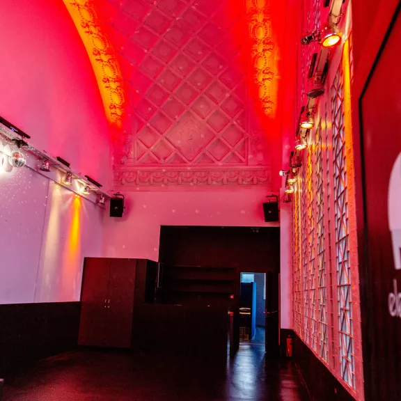Leerer Clubraum mit roter Beleuchtung und Elefantenlogo an der Wand
