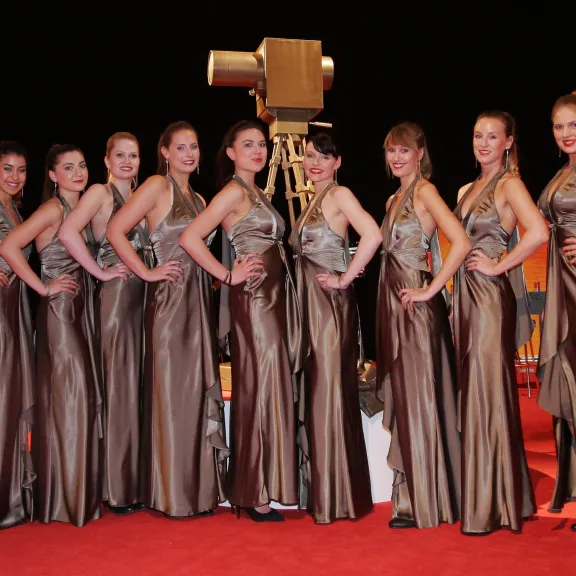 Professionelle Hosts und Hostessen von cinnamon in eleganter Abendgarderobe auf einem roten Teppich bei einer exklusiven Gala und VIP Veranstaltung.