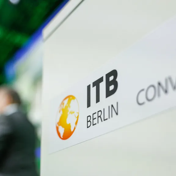 ITB Berlin Convention Logo auf einem Schild, Person unscharf im Hintergrund.