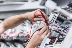 Nahaufnahme zweier Hände mit Voltmeter