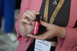 Close-Up auf eine Person, die ein Duftflasche mit der Aufschrift "Neuro360" hält. 