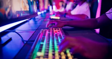 Diverse gamer group with african ethnicity players playing competitive MOBA PvP top down view computer game on a stage. Clos…