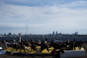 Menschen sitzen auf Liegestühlen und genießen den Ausblick auf die Skyline von Berlin