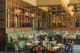 Elegant eingerichtetes Restaurant mit gedeckten Tischen und warmem Licht.