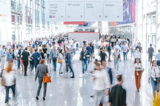 Messebesucher im Foyer einer großen Messehalle auf dem Messegelände Frankfurt am Main