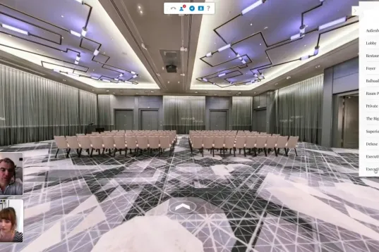 Moderner Konferenzraum mit leeren Stuhlreihen und futuristischer Beleuchtung.