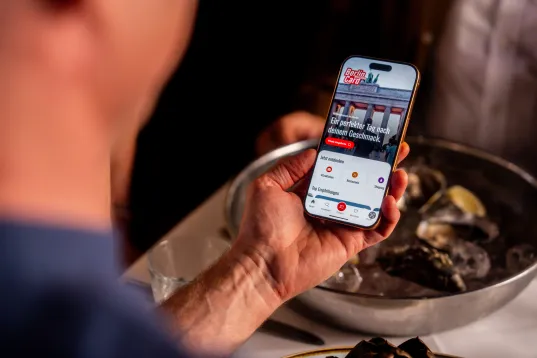 Ein Mann hält ein Smartphone auf dem die Berlin WelcomeCard zu erkennen ist
