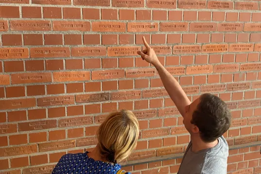 Auf dem Bild sind zwei Menschen zu sehen vor einer Kirche