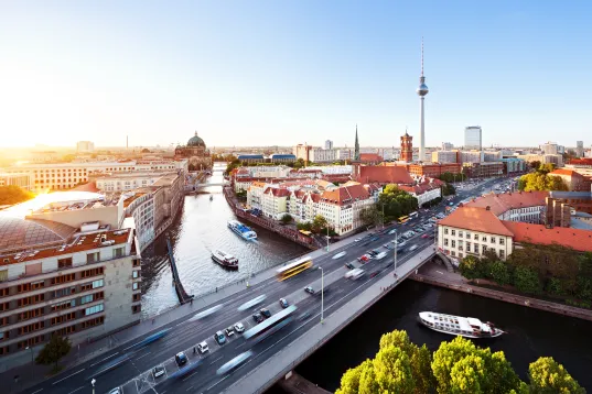 Cityscape from the east side of Berlin with sunset. Traffic on a big city and ships on the river spree.