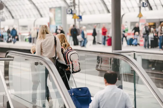Hier sind Menschen bei einer Anreise im Hauptbahnhof Berlin zu sehen
